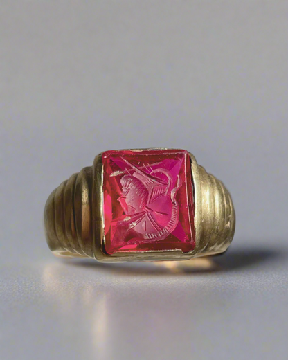 Gold ring with a pink gemstone on a gray background